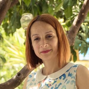 Verona Gjergji, Owner of Milingona Hostel, smiling in front of the hostel building